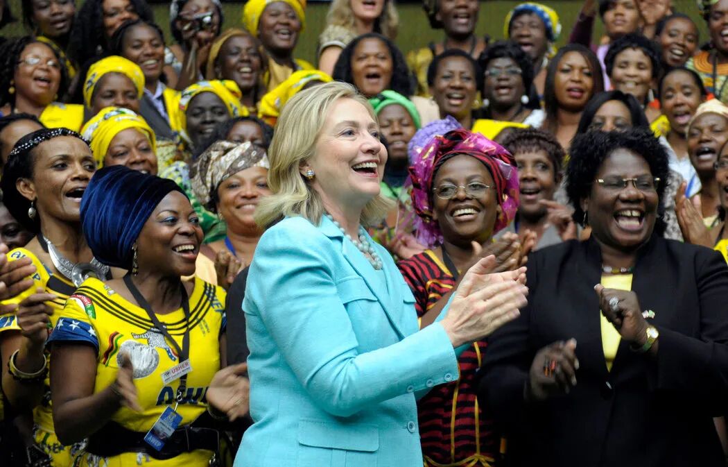 希拉里2012年在赞比亚卢萨卡穆隆古希国际会议中心欣赏“非洲妇女创业计划”成员为她献上的歌曲时鼓掌。